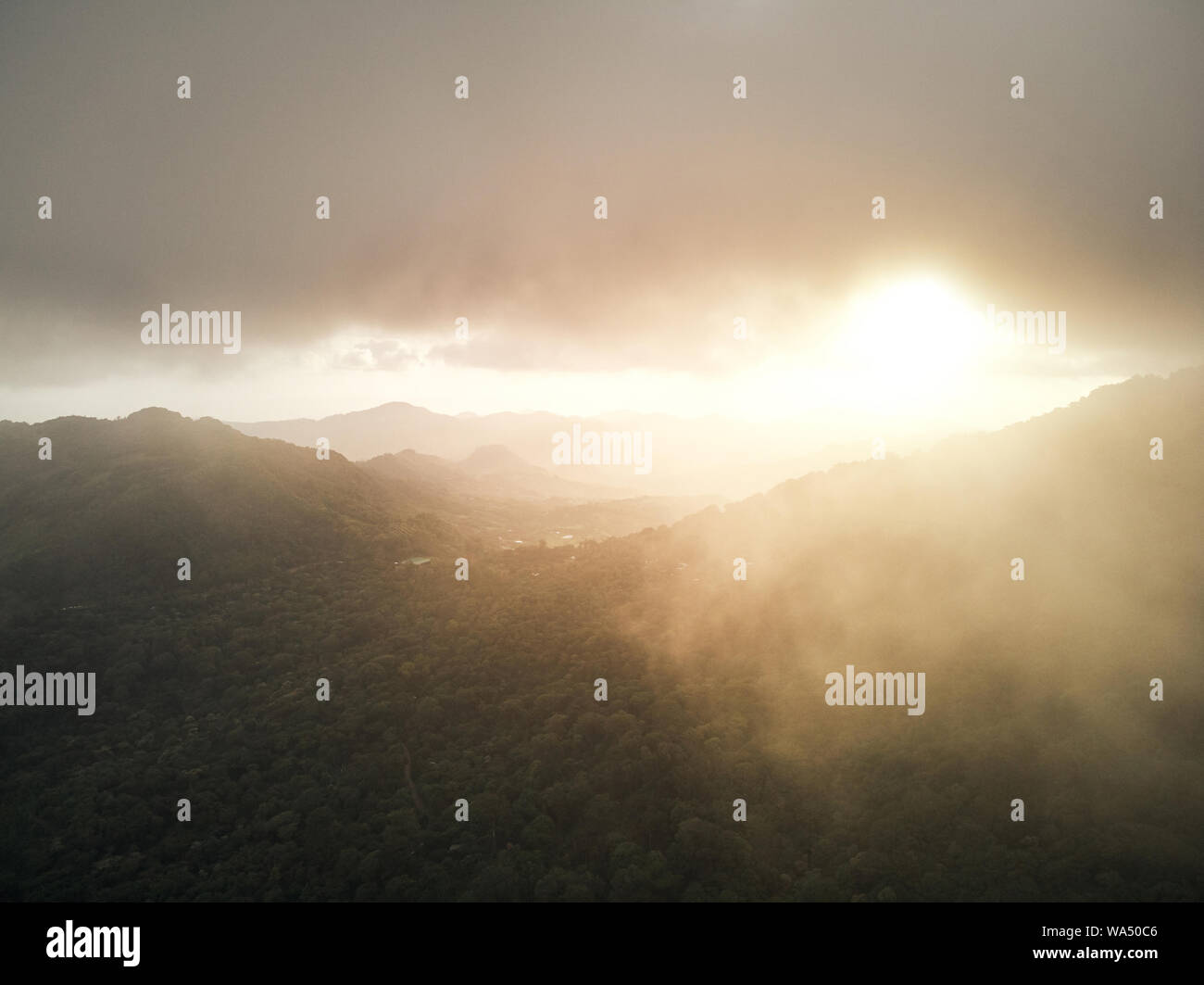 Foggy sunset over mountain aerial above drone view Stock Photo