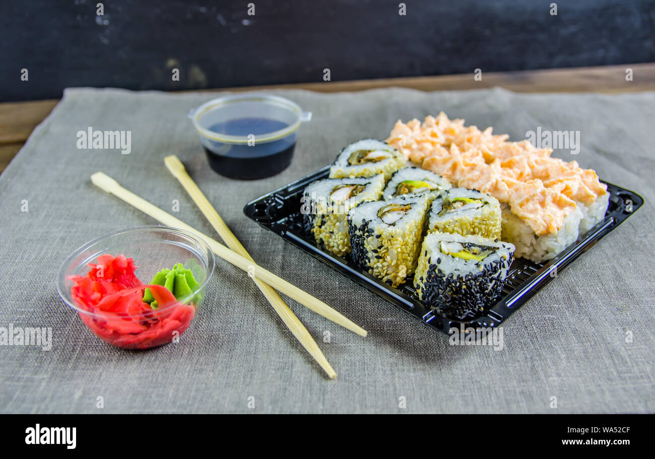delivery of rolls at home. Rolls in a box. Sticks, soy sauce. Stock Photo