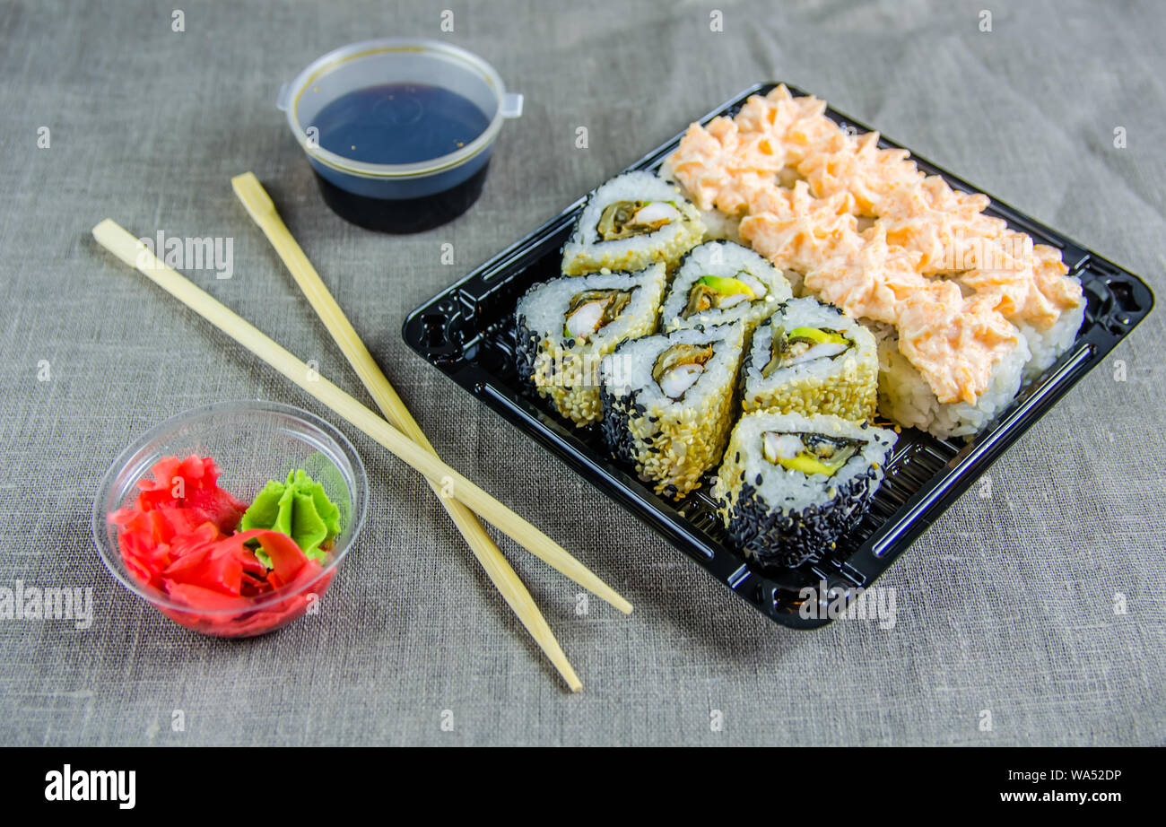 delivery of rolls at home. Rolls in a box. Sticks, soy sauce. Stock Photo