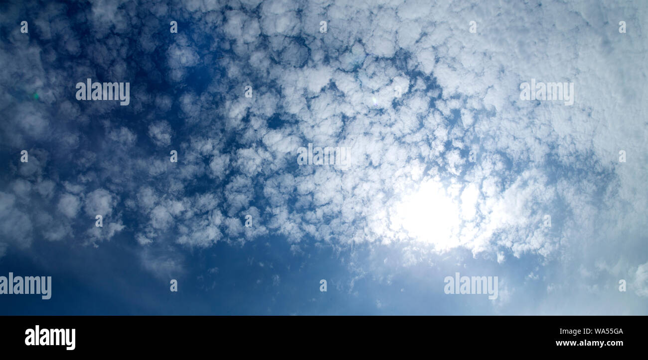 Deep blue sky with white fluffy clouds Stock Photo