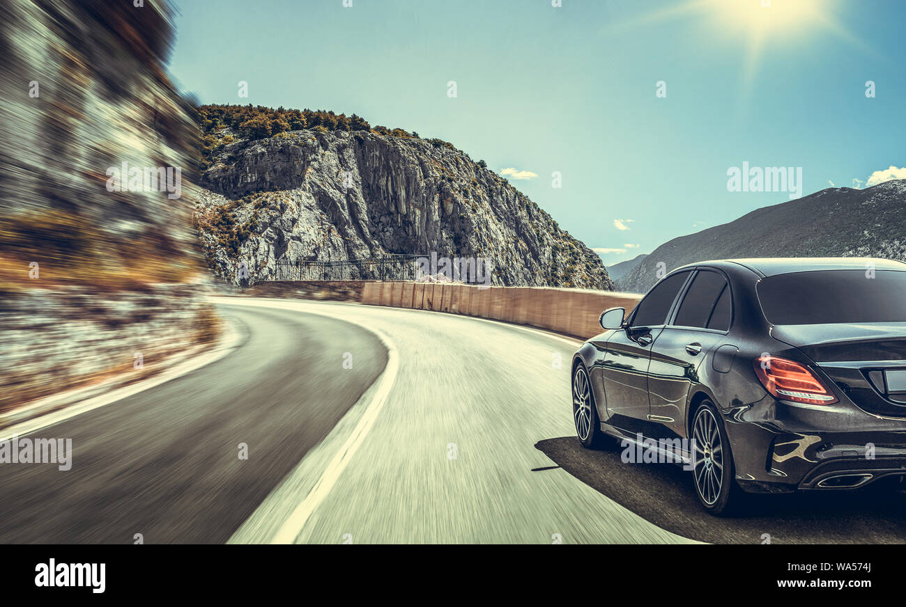 The car moves on a mountain road on a summer sunny day. Stock Photo