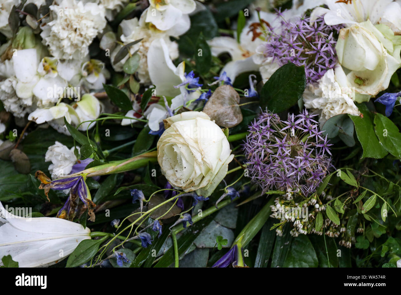 Slightly withered funeral flowers on a grave Stock Photo