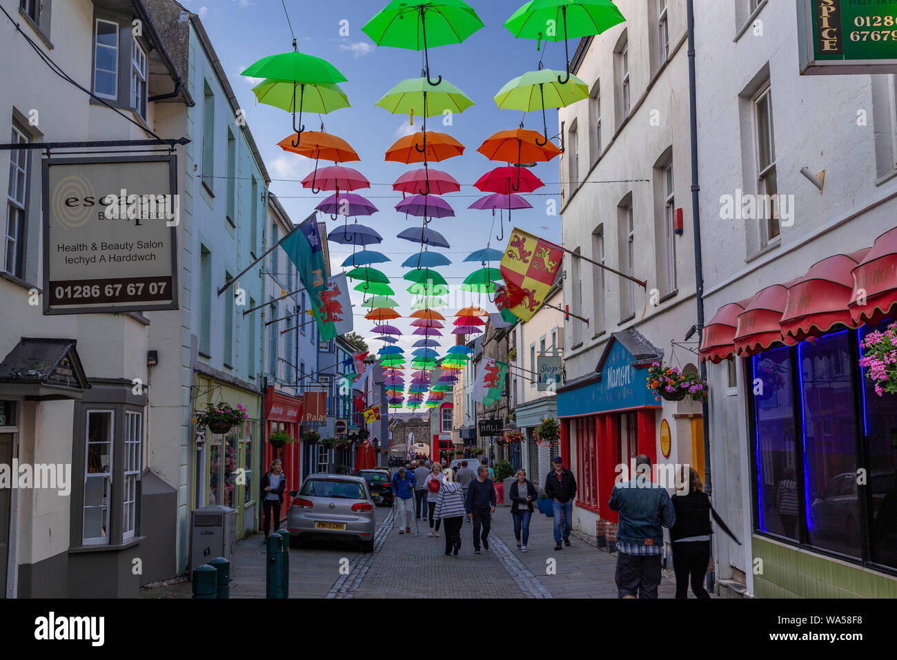 Multi-coloured umbrellas over Palace Street, Caernarfon, North Wales Stock Photo