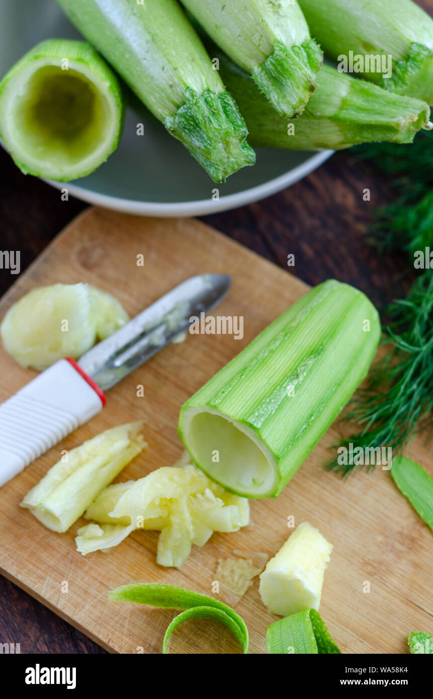 Premium Photo  Peeling fresh green zucchini with peeler. process of  cleaning raw squash with a vegetable peeler.