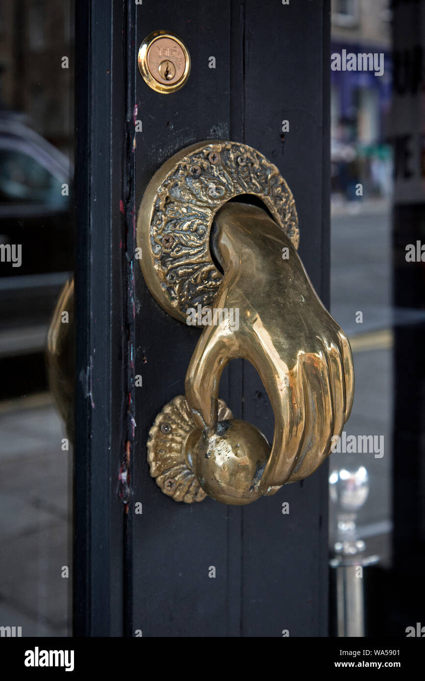 Brass door handle in the shape of a hand opening a door, Edinburgh