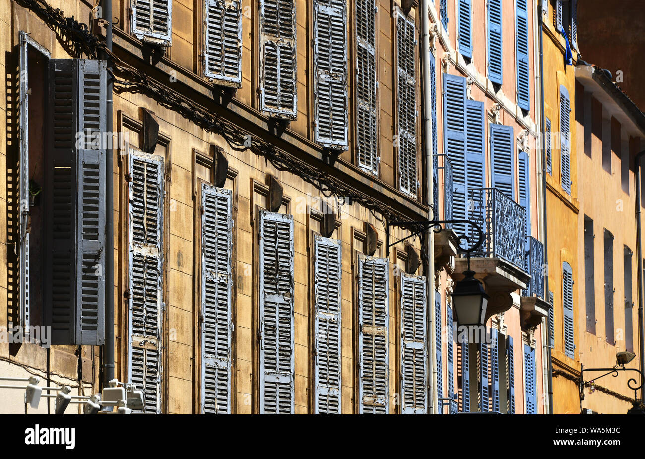 windows with closed shutters in afternoon sun Stock Photo