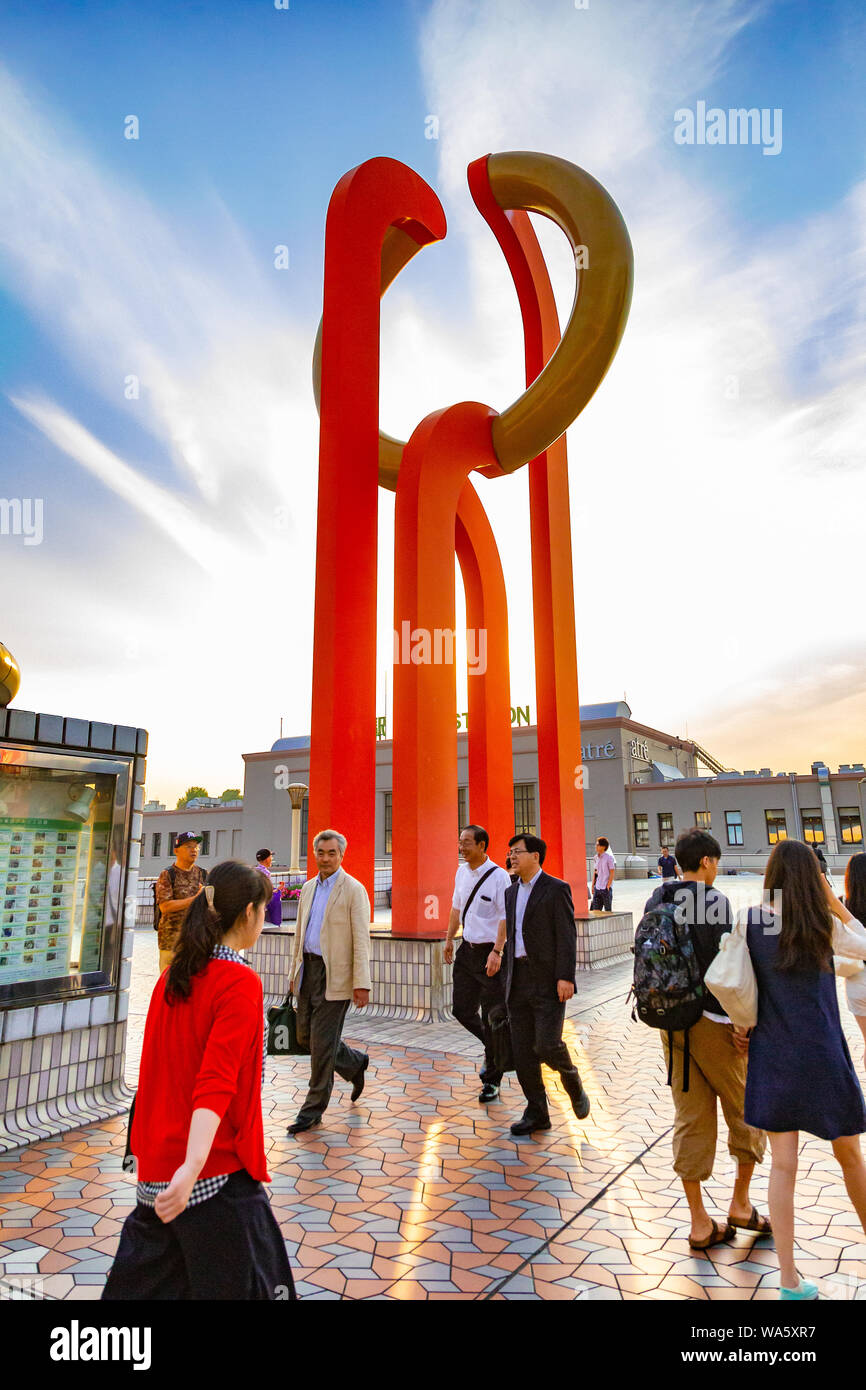 Ueno, Japan - 15 June 2015 - People walk on pedestrian deck near an orange sculpture outside of Ueno station on June 15, 2015 in Ueno, Japan Stock Photo