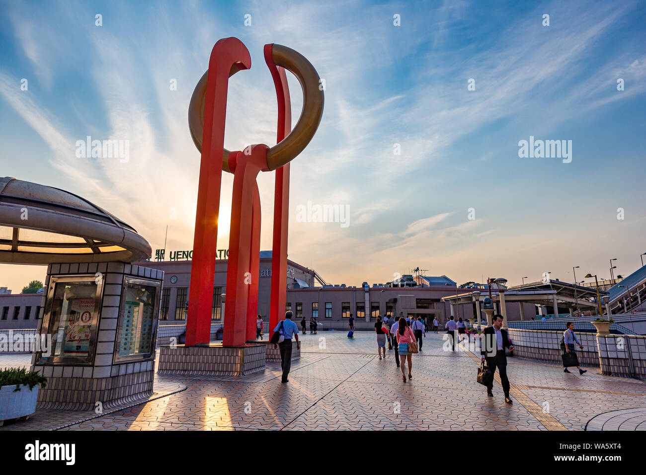 Ueno, Japan - 15 June 2015 - People walk on pedestrian deck near an orange sculpture outside of Ueno station on June 15, 2015 in Ueno, Japan Stock Photo