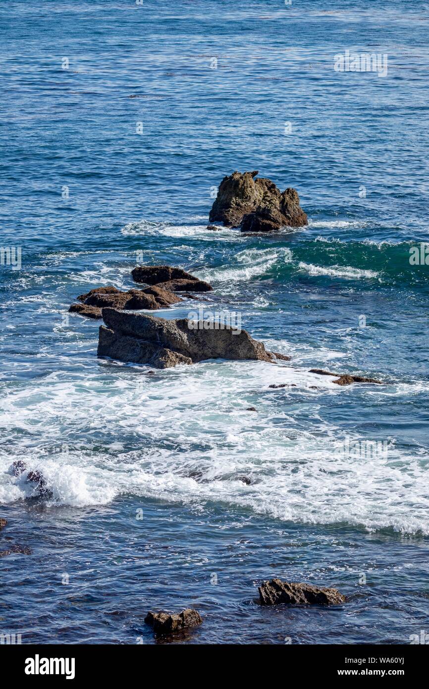 Waves crashing on rocks in the ocean Stock Photo