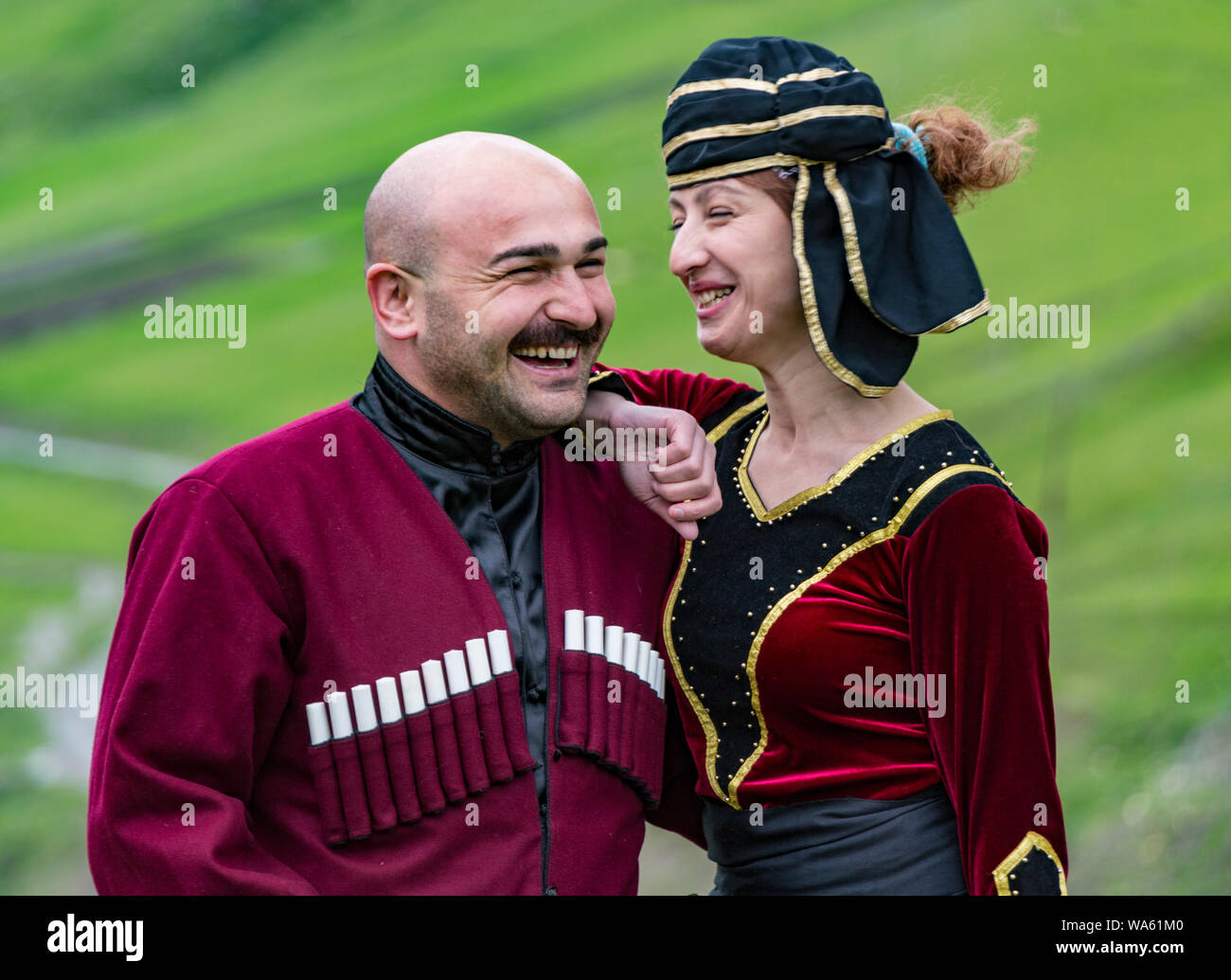 Mestia, Georgia - June 11, 2016 - Man and woman in traditional medieval garb share a laugh together Stock Photo