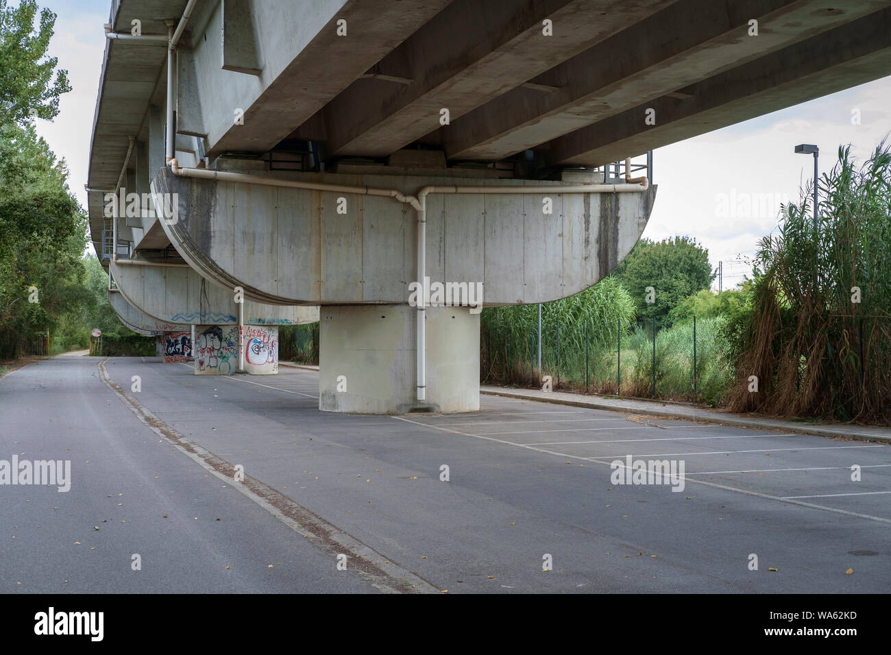 Florence outskirts, Italy. Empty and lonely road under an overpass and a parking lot. Stock Photo