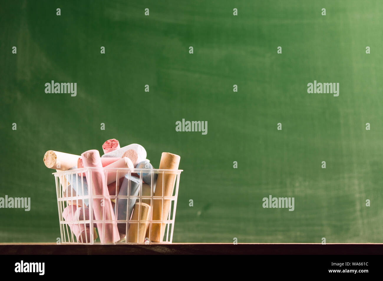 Many colorful piece of chalk in plastic basket. Back to school concept. Beginning school year. Selective focus Stock Photo