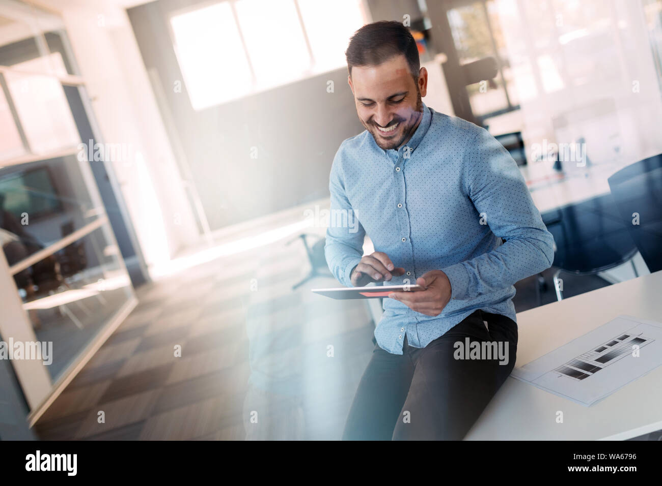 Portrait of a young successful manager using touch pad to prepare for ...