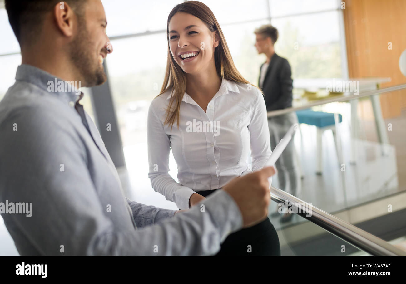 Business people discussing over documents in office lobby. Stock Photo