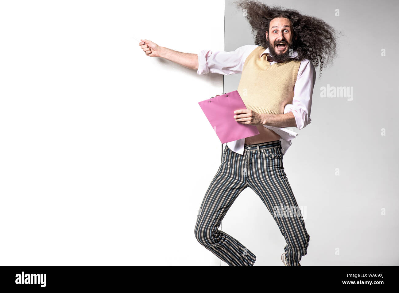 Jumping nerd pointing an empty billboard Stock Photo