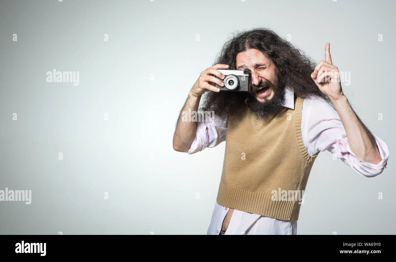 Portrait of a skinny man taking a photo with a vintage camera Stock Photo