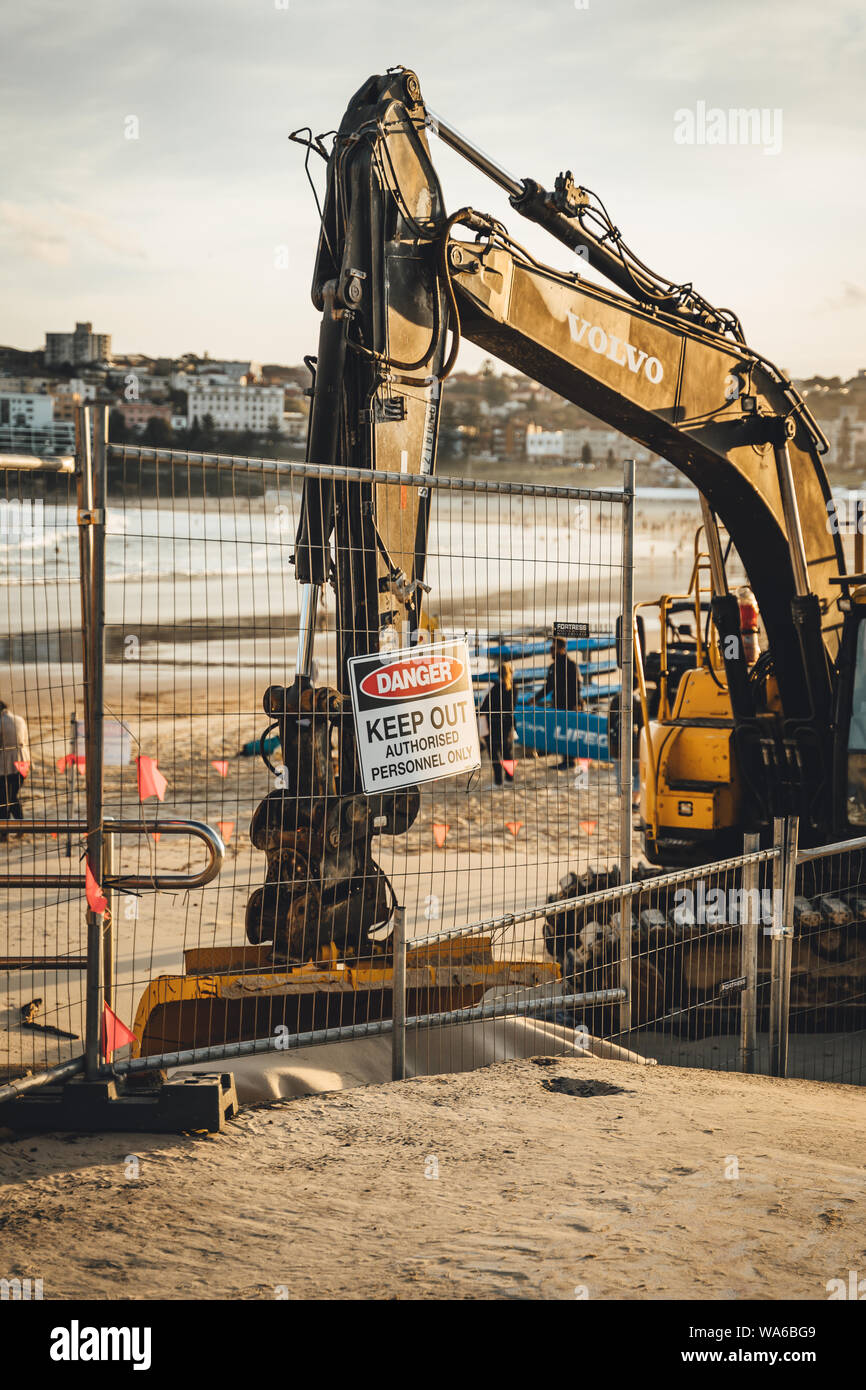 Bondi Beach, New South Wales - AUGUST 4th, 2019: Excavation earthmoving equipment sits on a construction site on the beach at North Bondi . Stock Photo