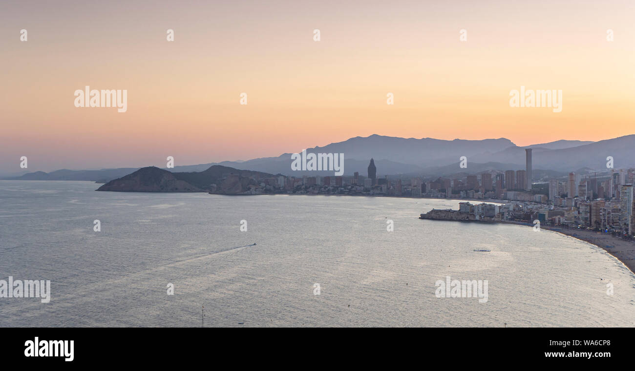Breathtaking sunset view of the coastline in Benidorm with high buildings, mountains, sea Stock Photo