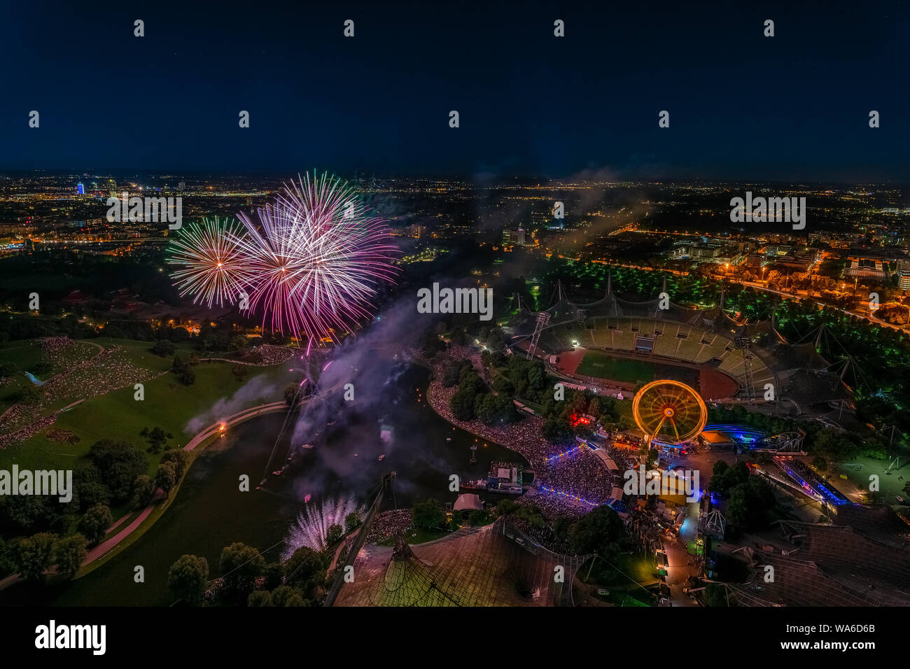Aerial panoramic cityscape view with bright fireworks lights in night Munich. Stock Photo