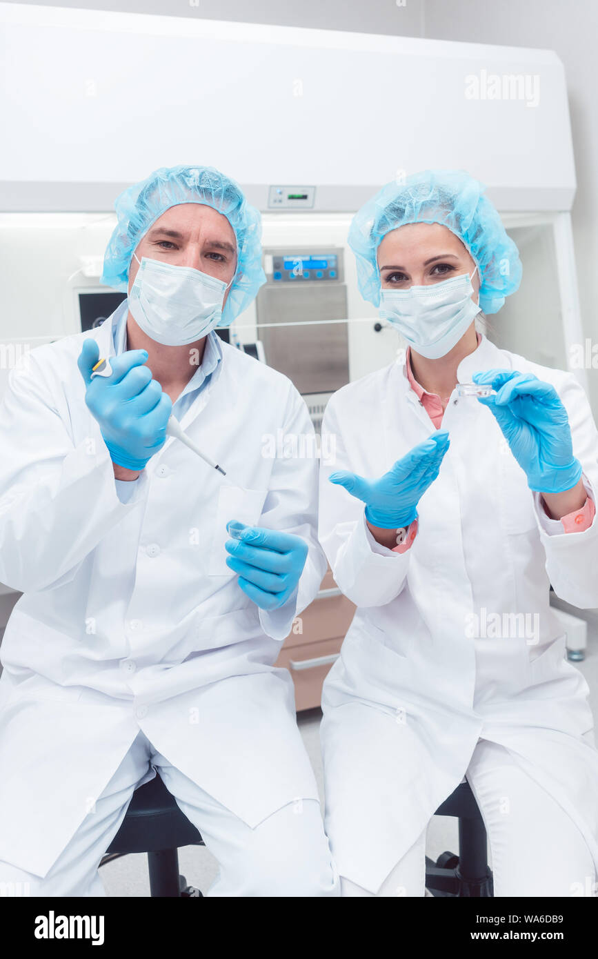 Scientists in biotech lab with pipette and sample dish Stock Photo