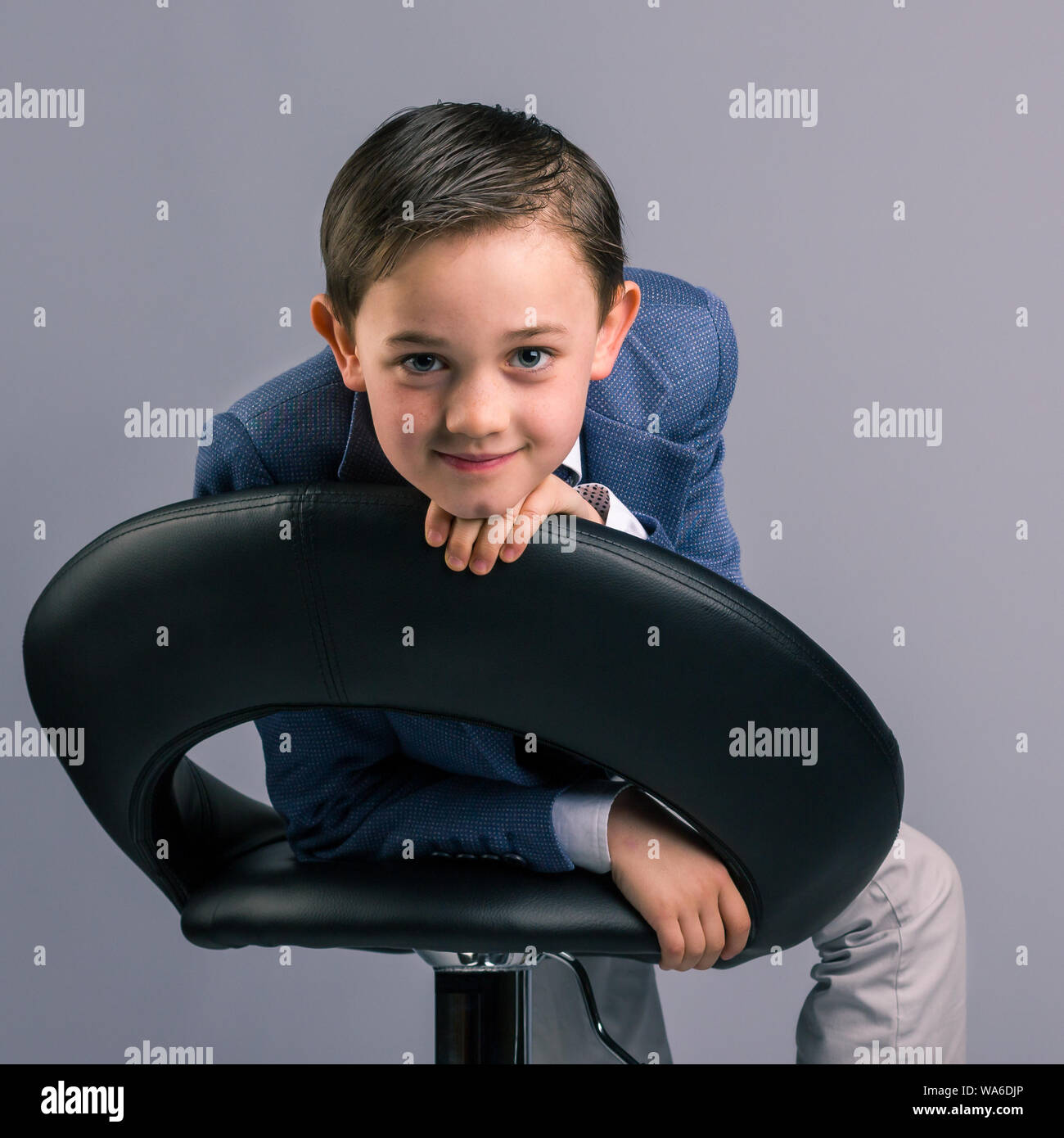 Portrait of handsome 8 year old boy dressed in suit looking over the