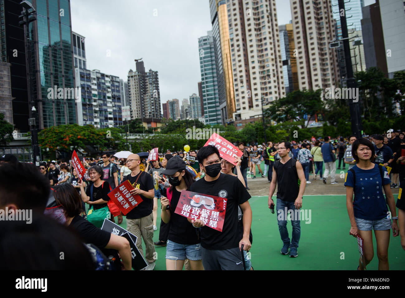 Hong Kong, China. 18th August 2019. Participants of a demonstration come with a mask and signs 'We demand an independent police investigation' to the protest rally in Victoria Park. Photo: Gregor Fischer/dpa Credit: dpa picture alliance/Alamy Live News Stock Photo