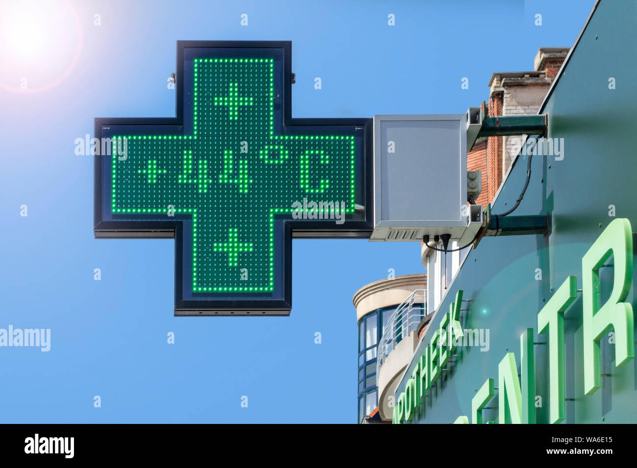 Thermometer in green pharmacy screen sign displays extremely hot temperature of 44 degrees Celsius / 44°C / 44 °C during summer heatwave / heat wave Stock Photo