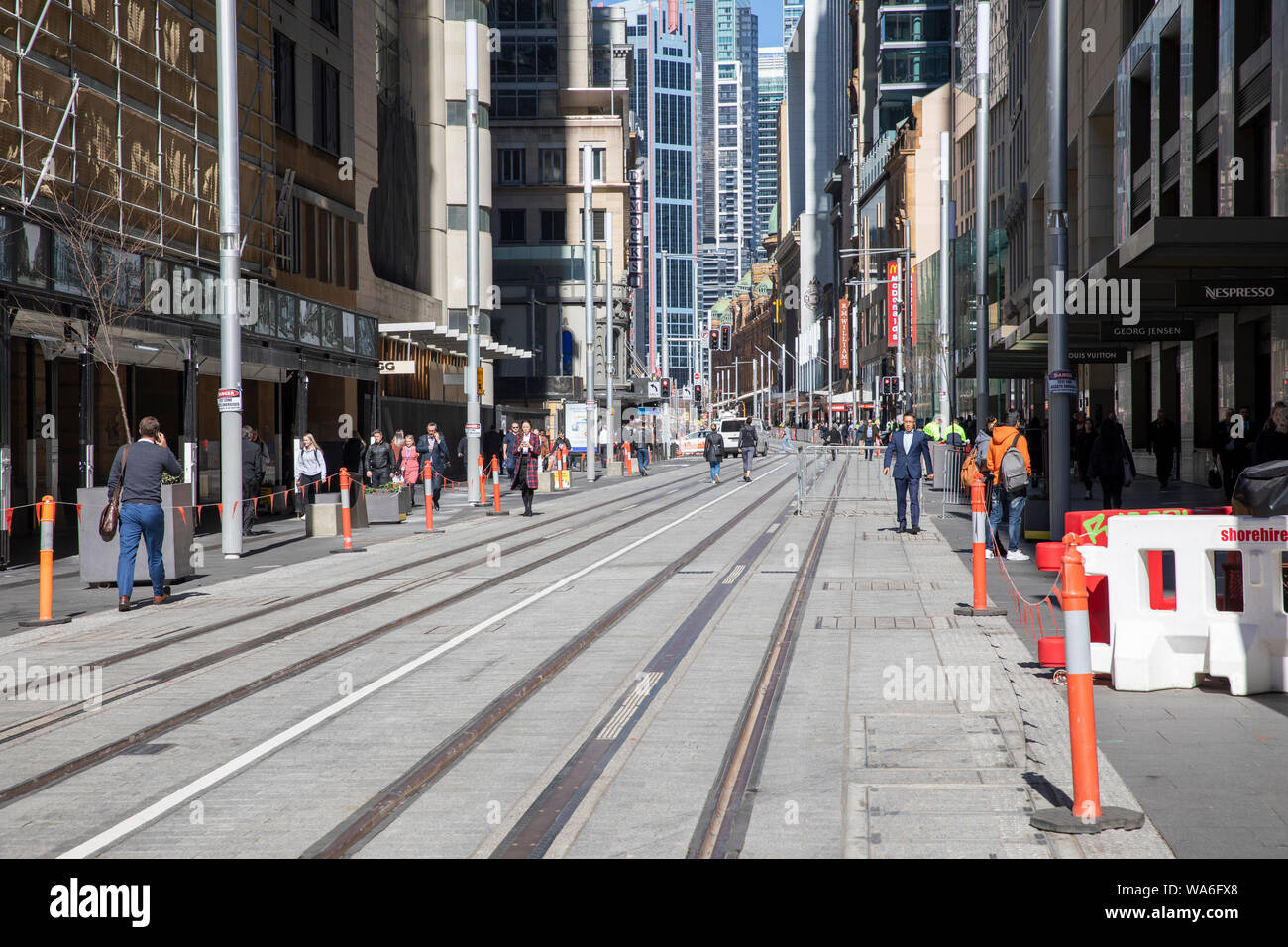 Sydney city centre office workers on George street in the central business district walk across completed sydney light rail tracks,Sydney,Australia Stock Photo