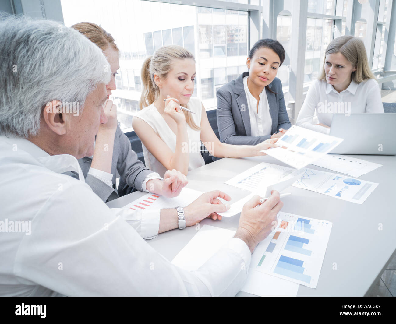 Group of business people discussing diagrams in office together Stock Photo
