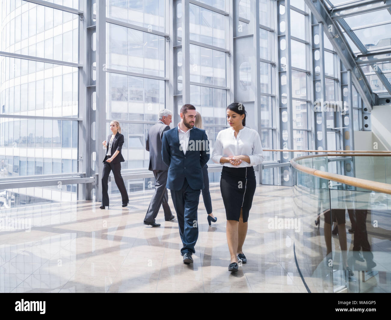 Business people walking in a modern hall of office building Stock Photo ...