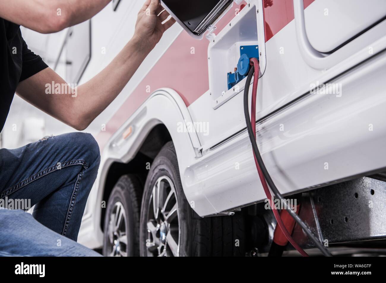 RV Park Electric Hookup. Caucasian Men in His 40s Connecting His Travel