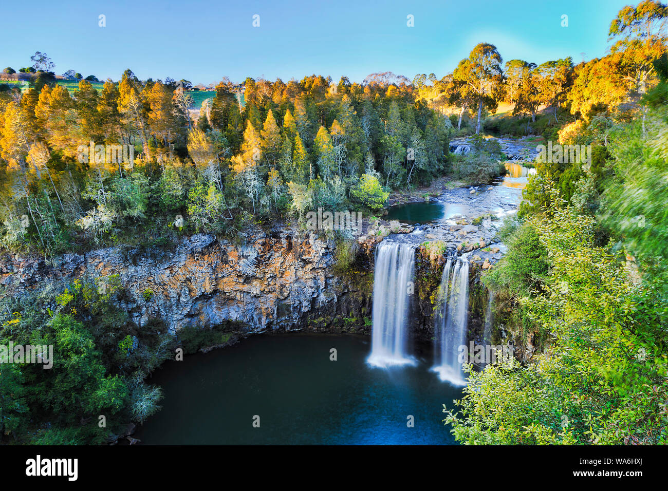 Elevated view over Dangar falls in Dorrigo National park near Dorrigo town in morning soft light with smooth water stream falling down to rock pool cu Stock Photo