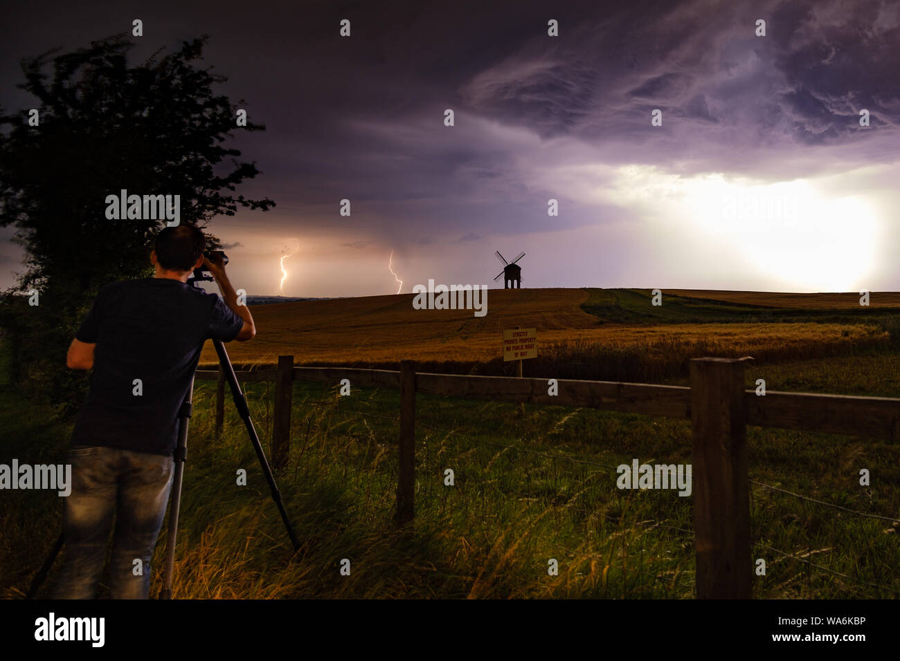 A photographer capturing a lightning storm over Chesterton Windmill, Warwickshire, UK Stock Photo
