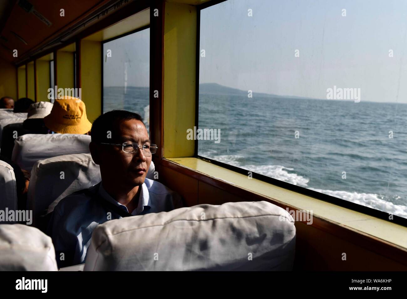 (190818) -- QINGDAO, Aug. 18, 2019 (Xinhua) -- Doctor Zhou Zhaojing takes a boat to the Lingshan Island of Qingdao, east China's Shandong Province, Aug. 16, 2019. The Lingshan Island is located some nine sea miles southeast off the west coast of Qingdao. Since 2013, the west coast new area has dispatched medical staff members to work by turns on the island. The 40-year-old Zhou was selected in 2018 as a general practitioner to work at the island's health service center. Despite harsh working and living conditions, Zhou and his colleagues never get slack at their work to provide medical service Stock Photo
