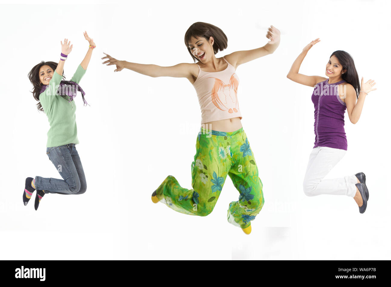 Young women jumping in mid air and smiling Stock Photo