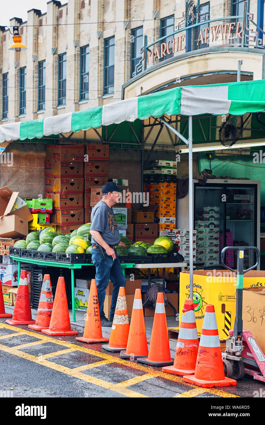 Canadian male salesperson sells watermelon at Atwater market in Montreal, Quebec, Canada. Stock Photo