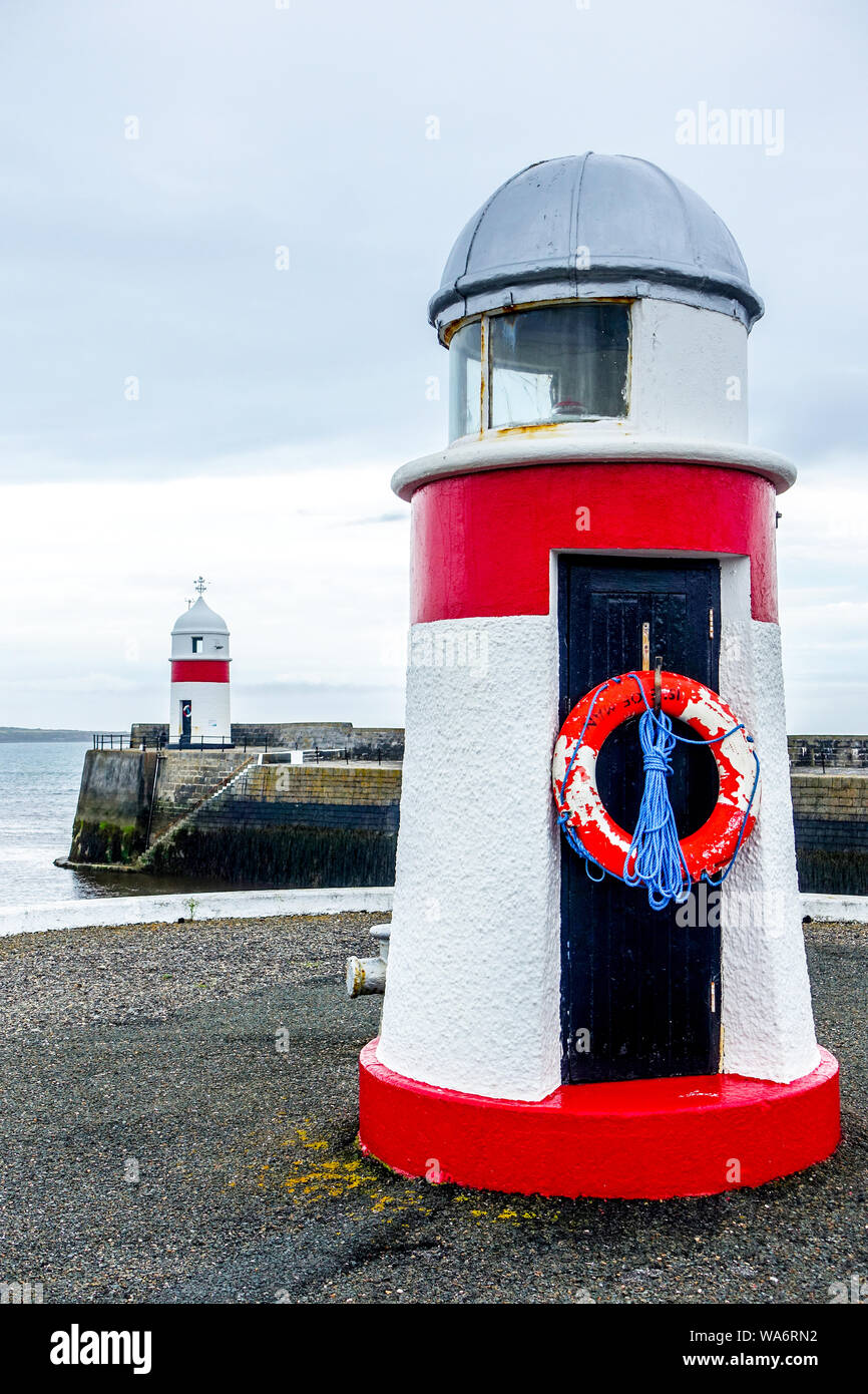 Red navigation beacons mark the Port (left) side of the entrance channel to Castletown Harbour, Isle of Man Stock Photo