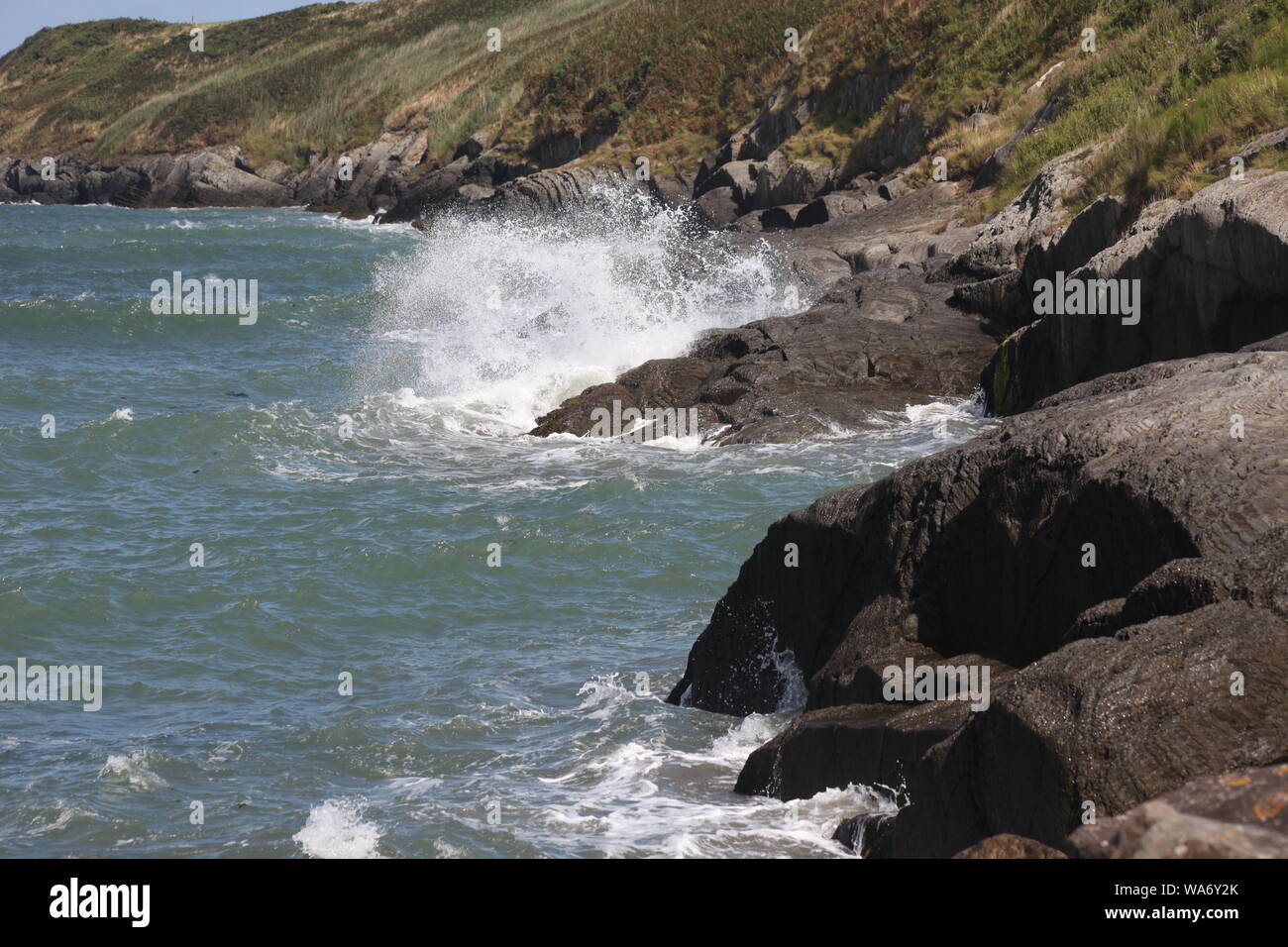waves breaking on rocks, Gwbert, Cardigan, Wales Stock Photo