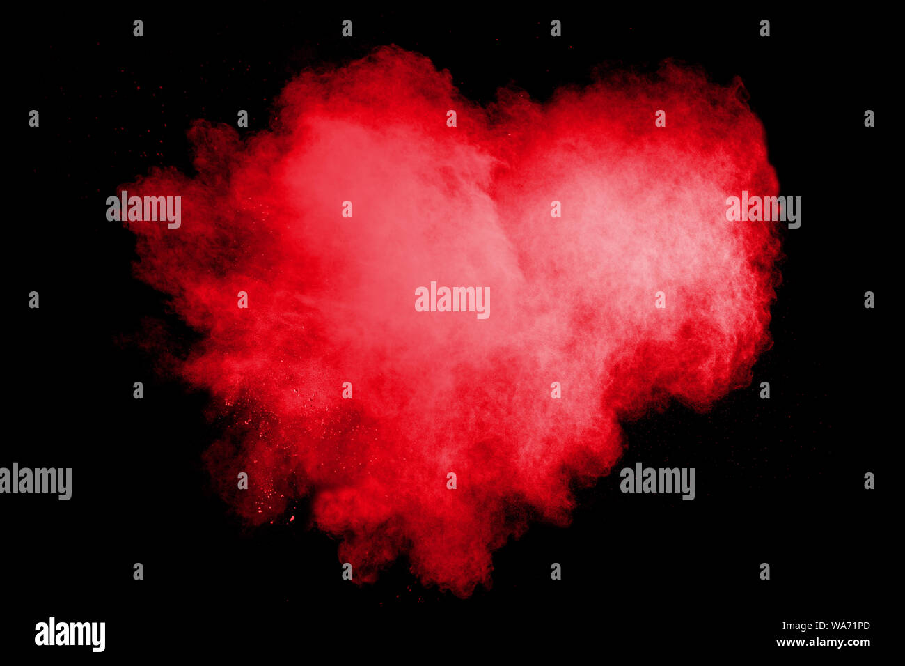 Red powder explosion cloud on black background. Freeze motion of red color dust  particles splashing. Stock Photo