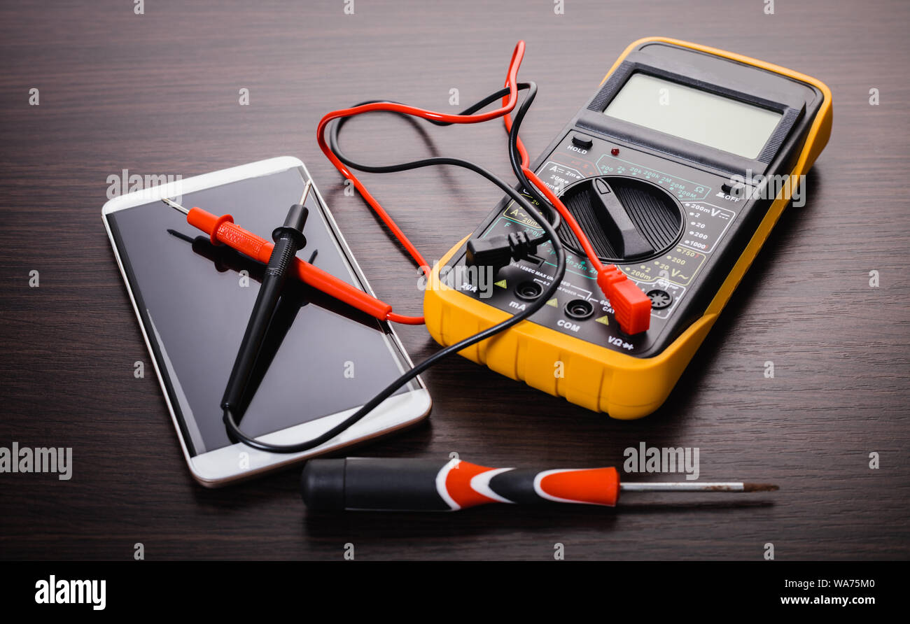 mobile phone and tool on wooden background Stock Photo