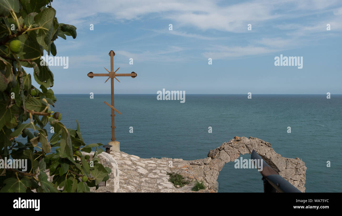 Christian cross of small church and stone arch at the end of Cape Kaliakra Stock Photo