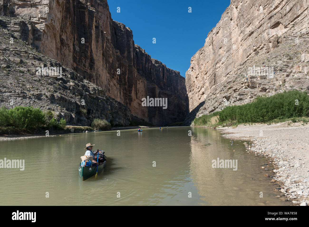 A guide from the Far Flung river-tour company brings up the rear of a canoe excursion by the Berkman family of Houston on the Rio Grande River through Santa Elena Canyon, deep in Big Bend National Park in Brewster County, Texas. Mexico is to the left, the United States to the right Stock Photo