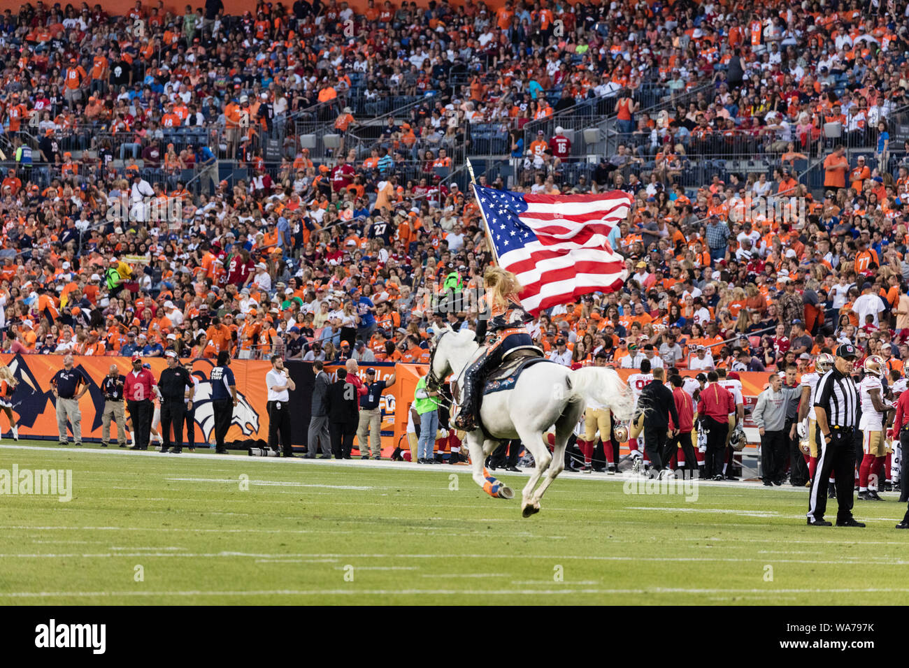 A  woman rides a white stallion across the field to celebrate a Denver Broncos touchdown during the team's National Football League game against the visiting San Francisco 49ers at the Sports Authority Field at Mile High stadium, Denver, Colorado Stock Photo