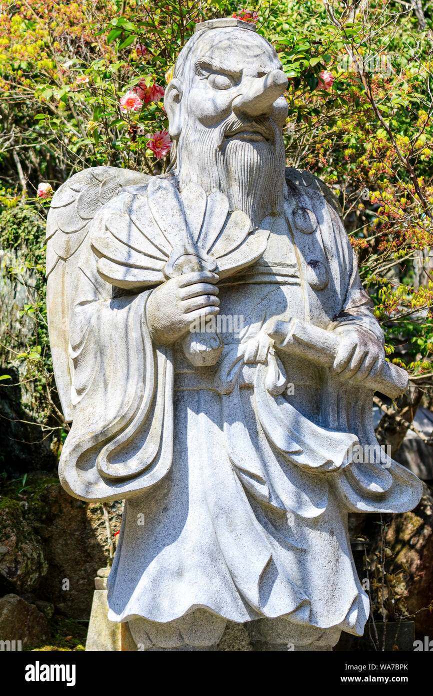 Japan, Miyajima. Daisho-in temple. Statue of the Japanese mystic figure, Karasu-Tengu, half man, half goblin with long beard and long pointed nose. Stock Photo