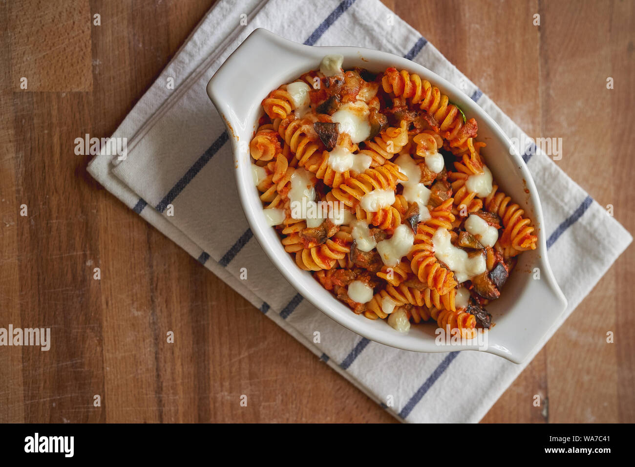 A homemade dish of fusilli pasta 'alla Norma', a Sicilian dish made with fried aubergines, mozzarella or ricotta cheese, tomato sauce and basil. Stock Photo