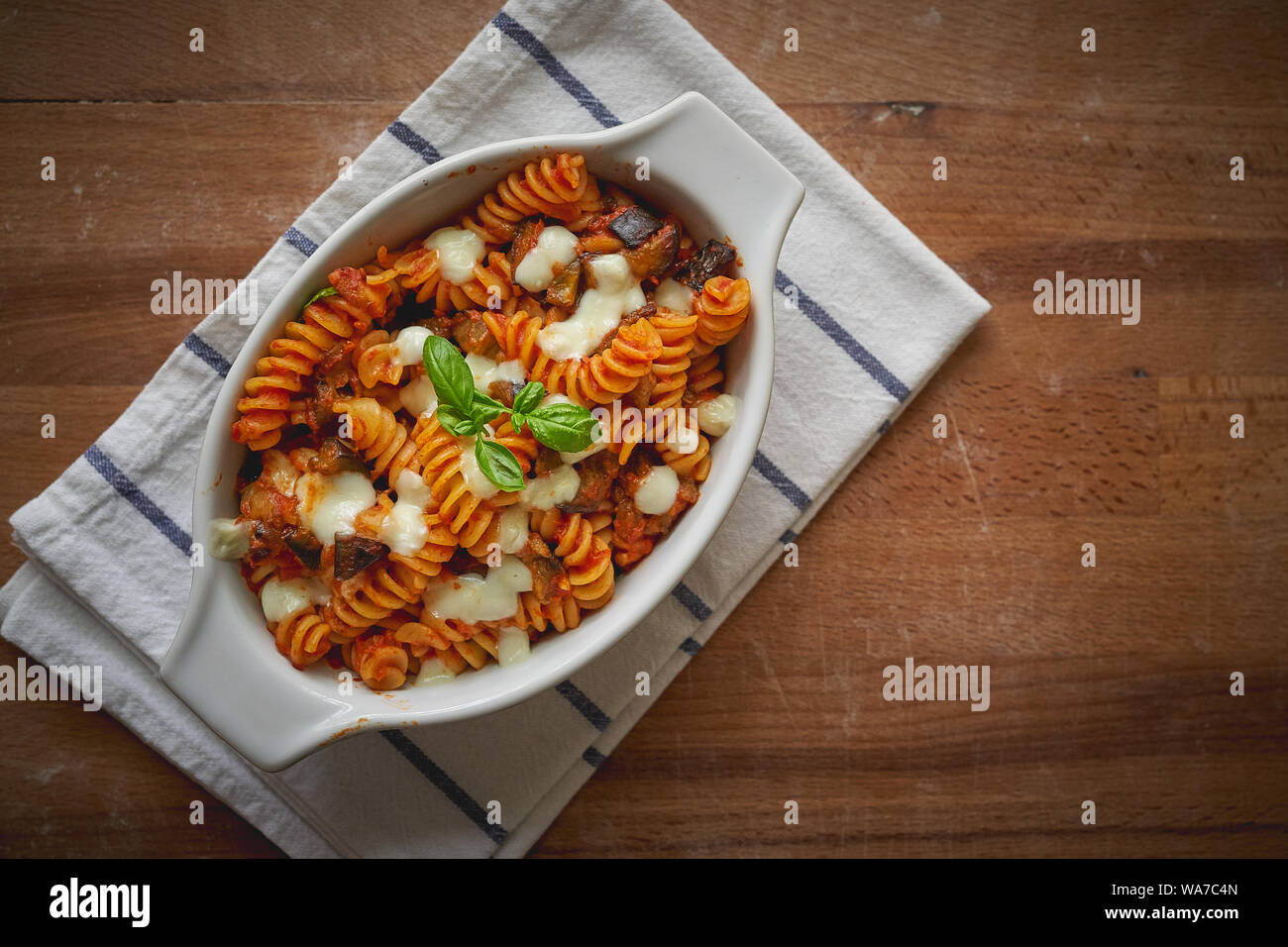 A homemade dish of fusilli pasta 'alla Norma', a Sicilian dish made with fried aubergines, mozzarella or ricotta cheese, tomato sauce and basil. Stock Photo