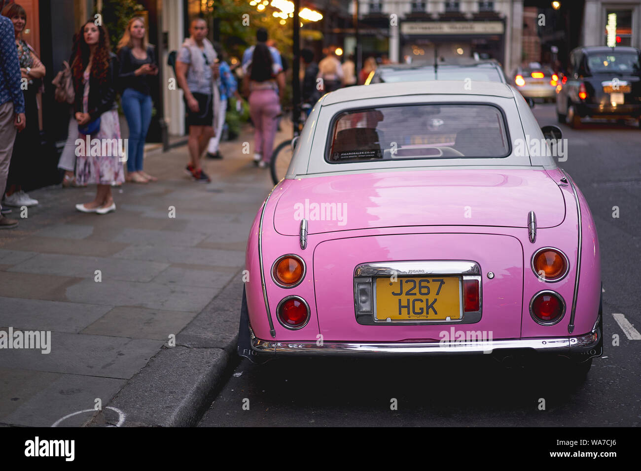 London, UK - August, 2019. A pink retro styled Nissan Figaro parked in a street close to Covent Garden in central London. Stock Photo