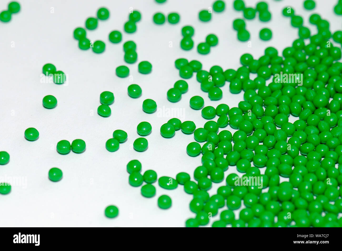 grünes Zylindergranulat für die kunststoffverarbeitende Industrie, green polymer resin for injection moulding Stock Photo
