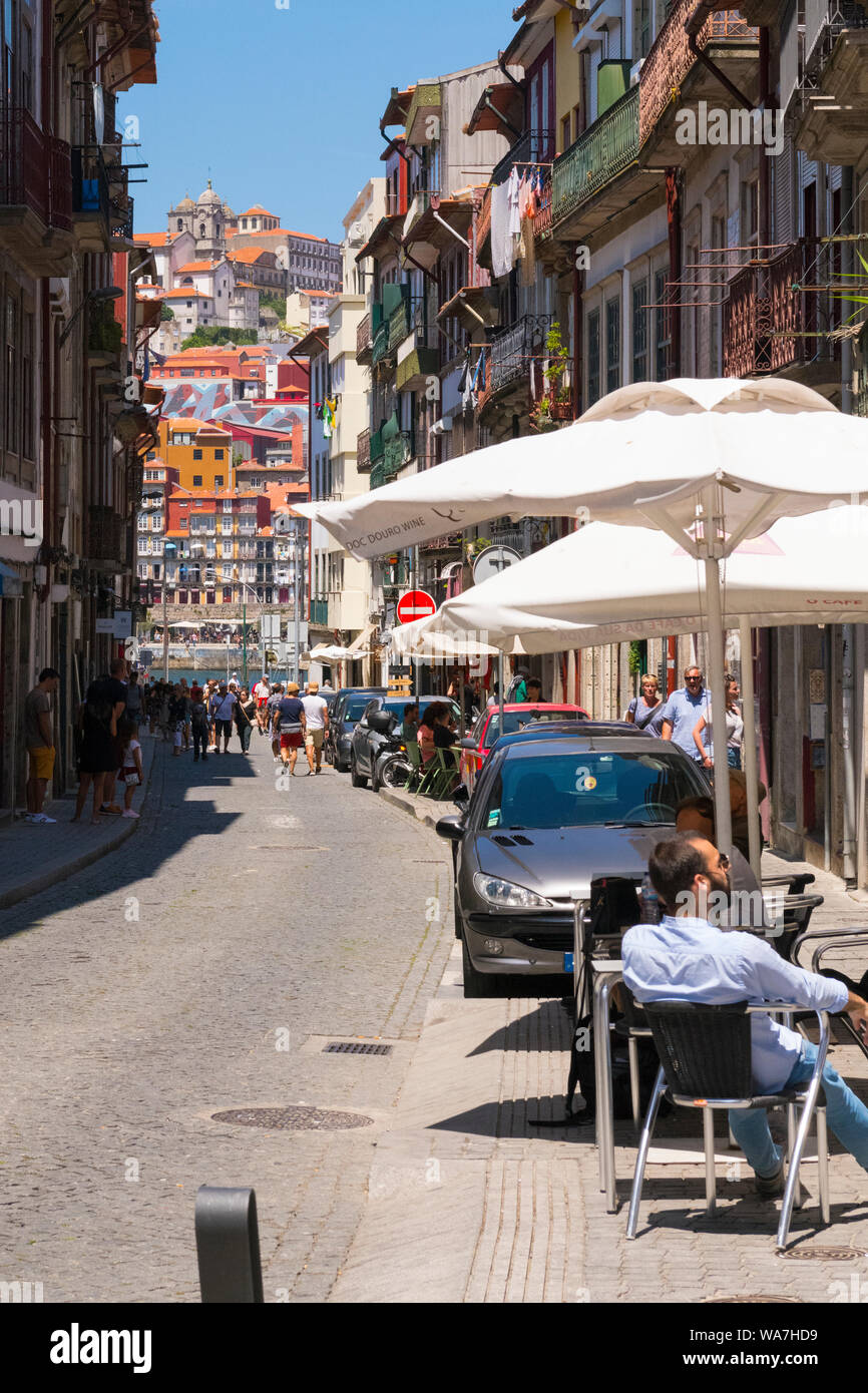 Portugal Vila Nova de Gaia street scene parasol cobbled lane panorama cityscape cathedral cars crowds washing laundry hanging balconies buildings Stock Photo