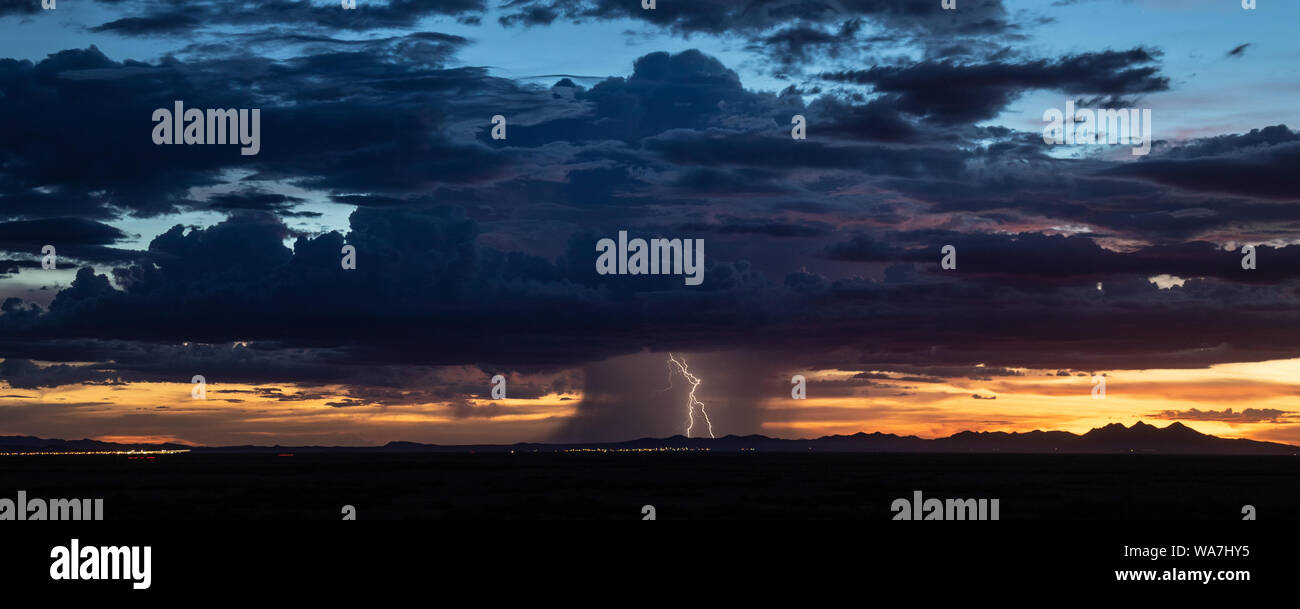 Lightning Bolts and Rain Drop from a Summer Monsoon Thunderstorm at Sunset near Columbus, New Mexico, USA Stock Photo